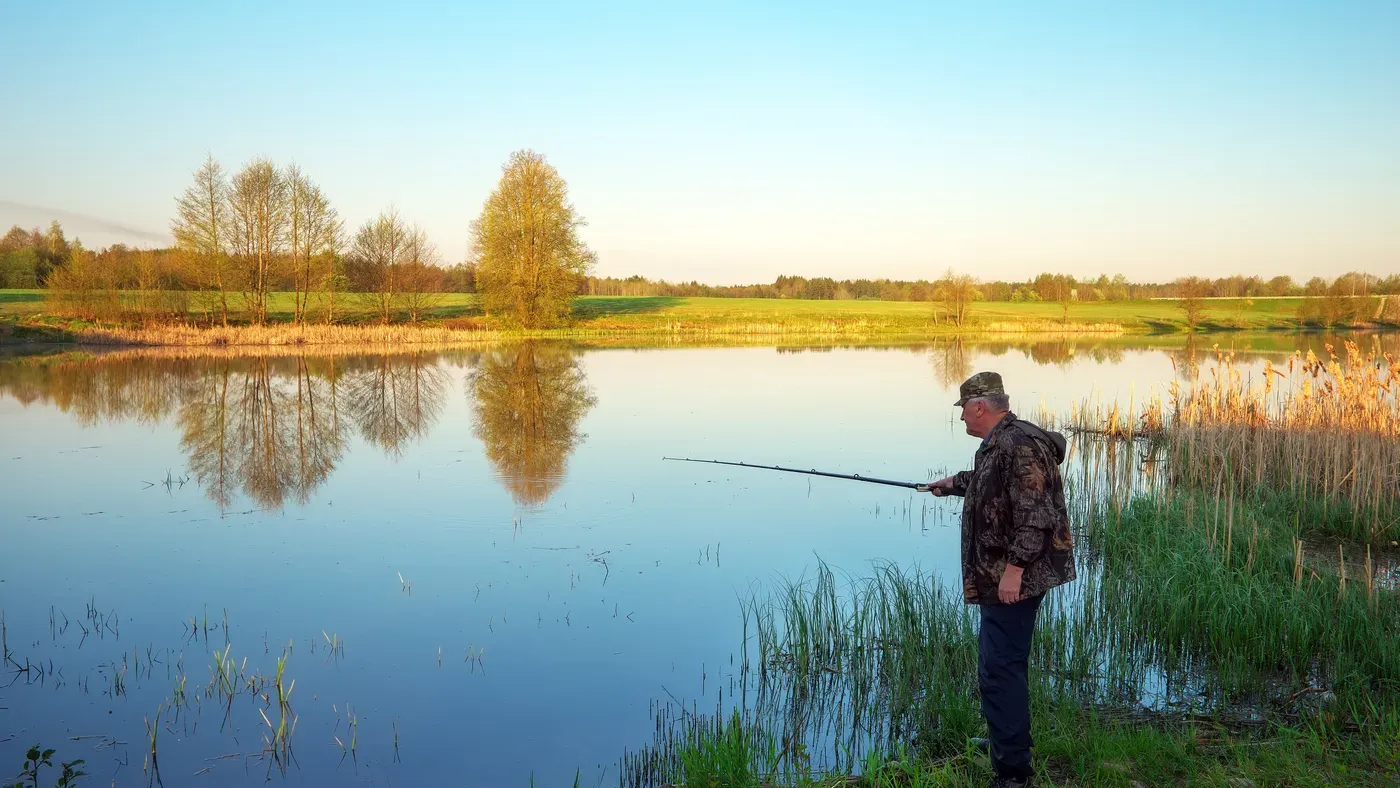 Fiskare som spinnfiskar vid vattnet